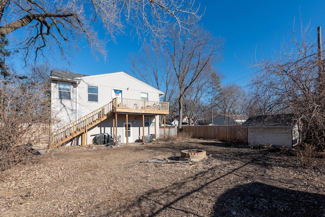 rear view of house featuring an outdoor fire pit, a deck, and a storage unit