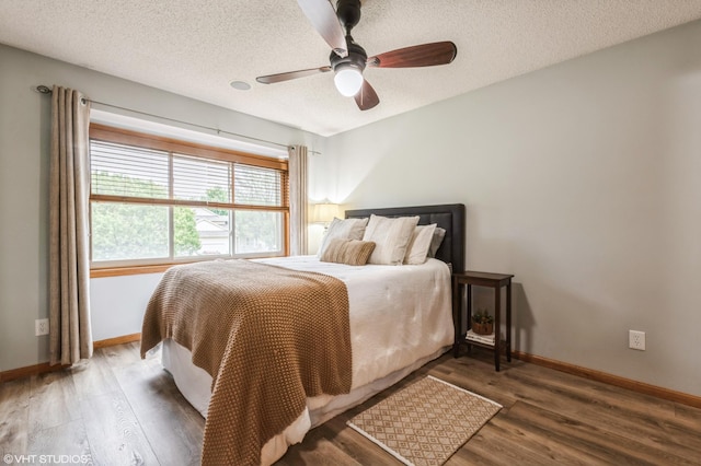 bedroom featuring ceiling fan, wood-type flooring, and a textured ceiling