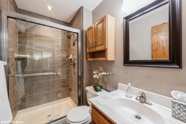 bathroom with an enclosed shower, vanity, and toilet