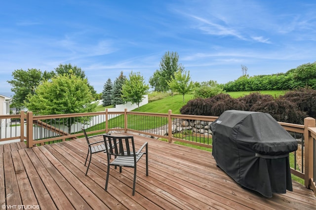 deck featuring area for grilling and a lawn