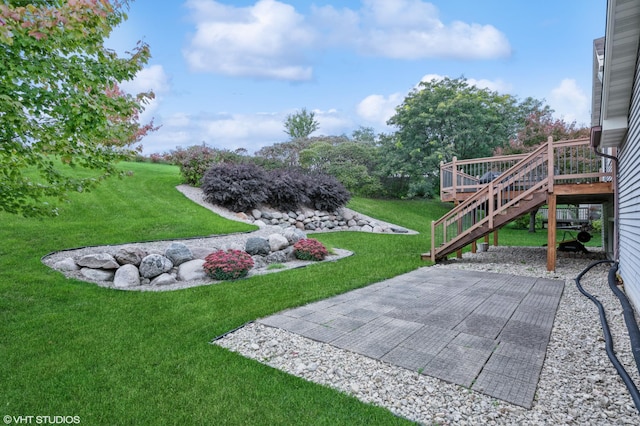 view of yard featuring a wooden deck and a patio