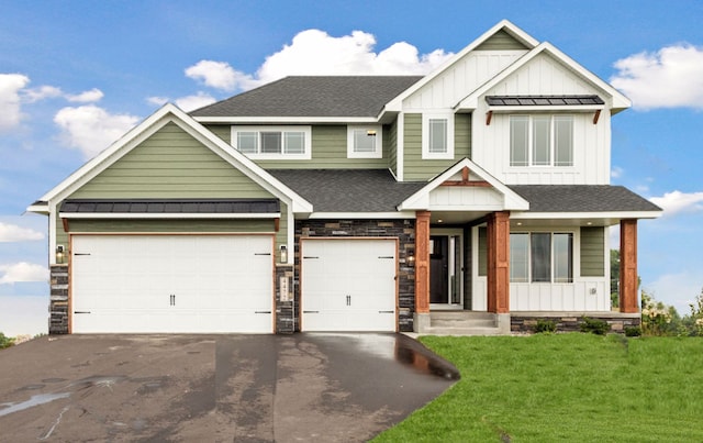 craftsman house with a garage and a front lawn