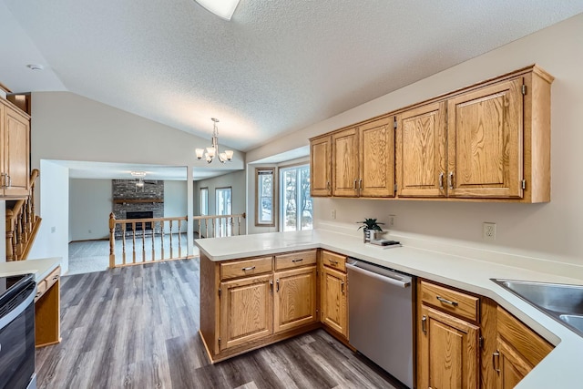 kitchen with decorative light fixtures, lofted ceiling, dark hardwood / wood-style flooring, stainless steel dishwasher, and kitchen peninsula