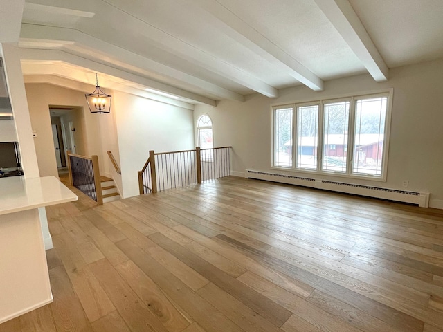 unfurnished living room featuring baseboard heating, vaulted ceiling with beams, an inviting chandelier, and light wood-type flooring