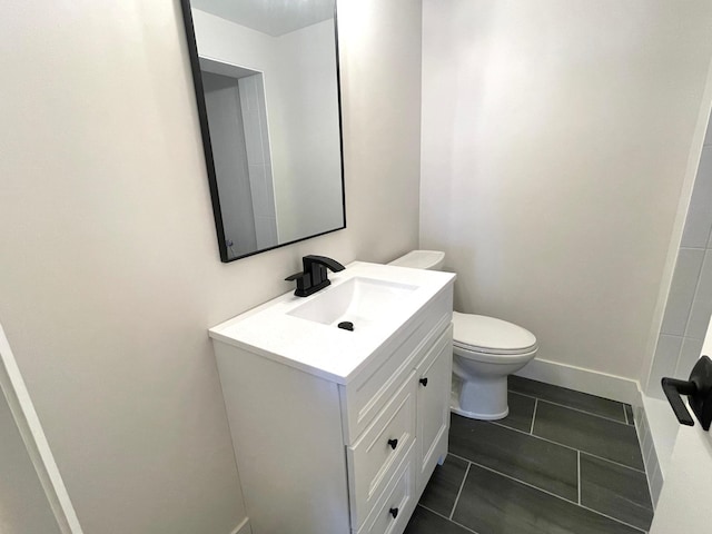 bathroom featuring vanity, tile patterned floors, and toilet