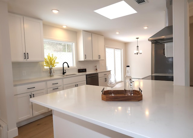 kitchen with sink, white cabinetry, dishwasher, pendant lighting, and exhaust hood