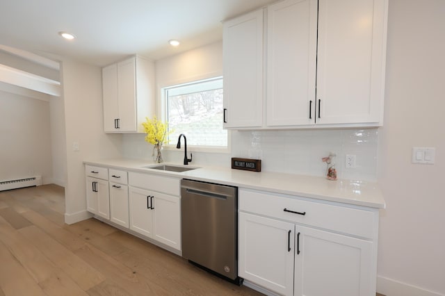 kitchen with decorative backsplash, stainless steel dishwasher, a sink, light wood finished floors, and white cabinetry