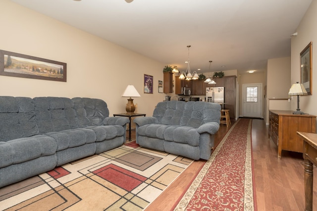 living room with an inviting chandelier and wood-type flooring