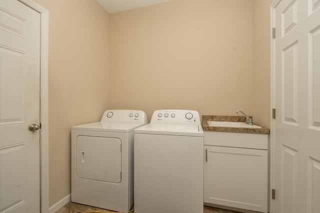 laundry area featuring sink, washing machine and dryer, and cabinets