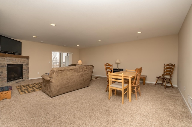 dining area with a fireplace and light carpet