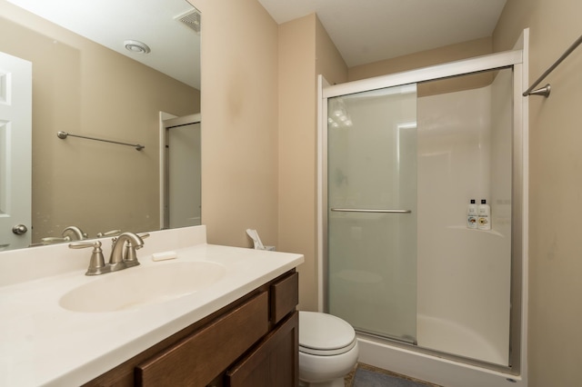 bathroom featuring vanity, toilet, and an enclosed shower