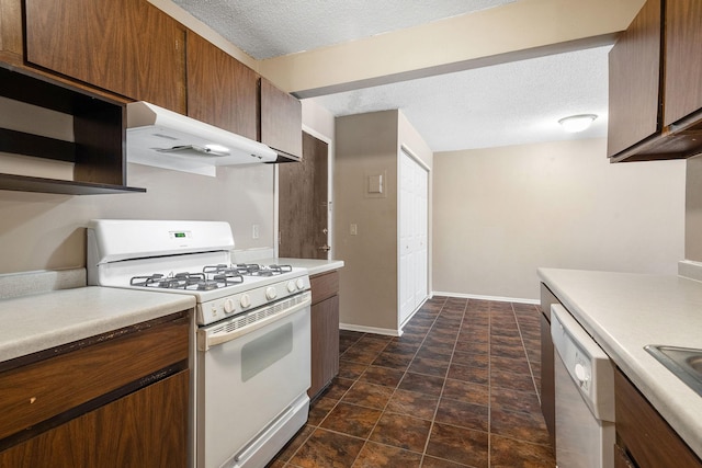 kitchen featuring sink, a textured ceiling, and white appliances