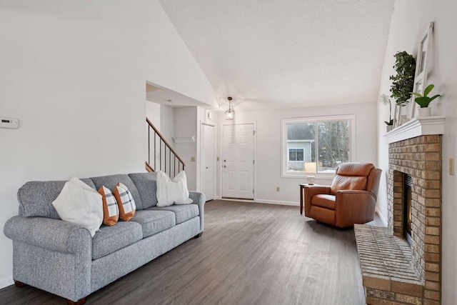 living room with wood finished floors, baseboards, high vaulted ceiling, stairs, and a brick fireplace