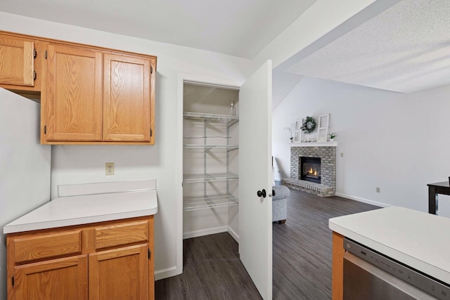 kitchen featuring stainless steel dishwasher, open floor plan, freestanding refrigerator, light countertops, and dark wood-style flooring