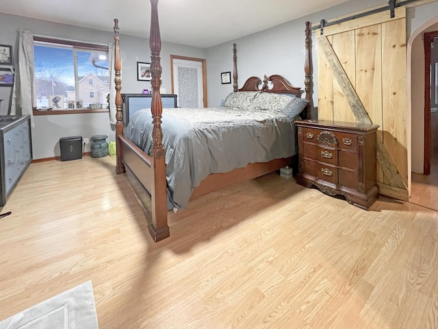 bedroom featuring light hardwood / wood-style flooring and a barn door