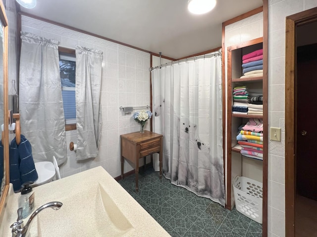 bathroom with tile walls, sink, and a shower with shower curtain