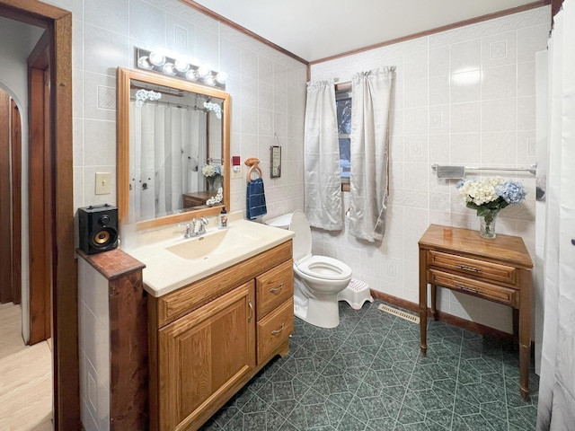 bathroom featuring vanity, toilet, and tile walls