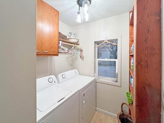 laundry area featuring light hardwood / wood-style floors, cabinets, and washing machine and clothes dryer