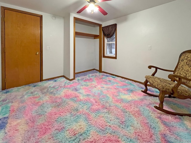 living area featuring light carpet and ceiling fan