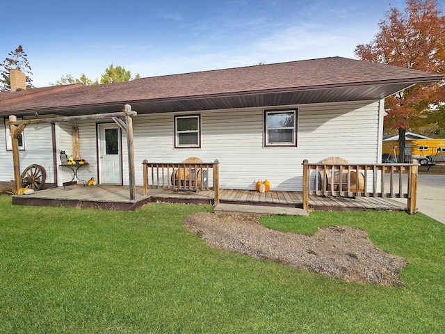 back of property with a wooden deck and a yard