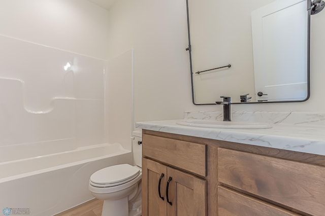 full bathroom featuring hardwood / wood-style flooring, vanity, shower / washtub combination, and toilet