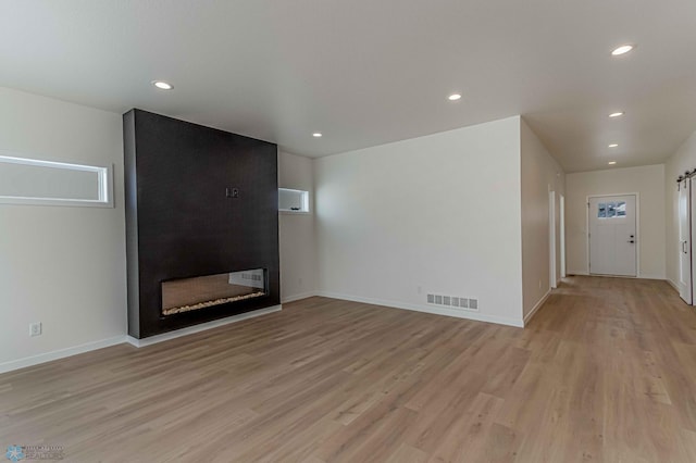 unfurnished living room featuring a fireplace and light wood-type flooring