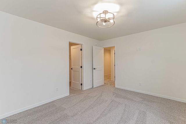 unfurnished room featuring light carpet
