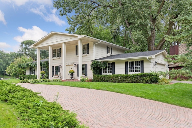 greek revival inspired property with a garage and a front yard