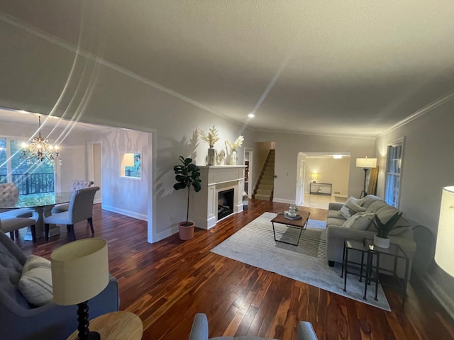 living room featuring a textured ceiling, ornamental molding, dark hardwood / wood-style floors, and a chandelier