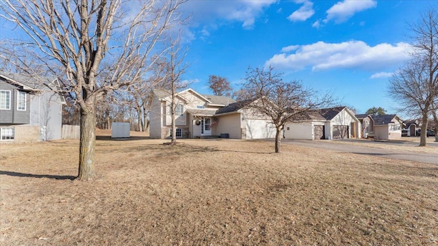 view of front of home with a garage, a front yard, driveway, and a residential view