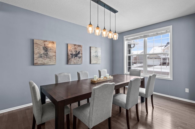 dining room featuring dark hardwood / wood-style floors and a textured ceiling