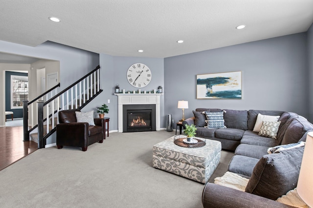 carpeted living room featuring a textured ceiling