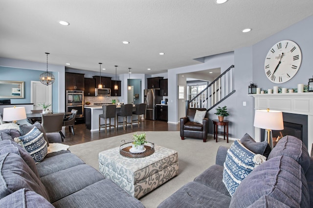 living room with an inviting chandelier and a textured ceiling