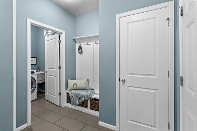 mudroom with washer / dryer and a textured ceiling