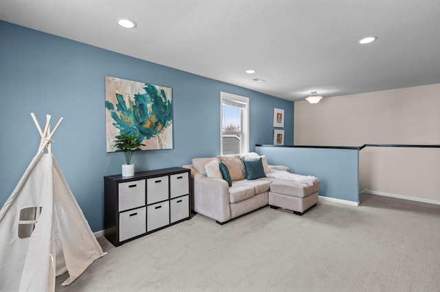 sitting room featuring light colored carpet and a textured ceiling