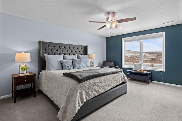 carpeted bedroom featuring a textured ceiling and ceiling fan