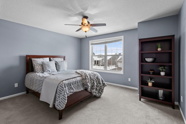 carpeted bedroom featuring ceiling fan and a textured ceiling