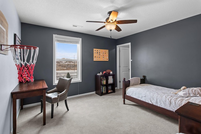 bedroom featuring light carpet, ceiling fan, and a textured ceiling