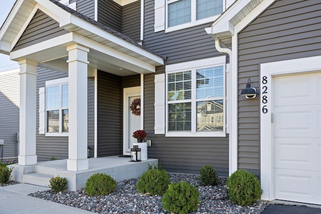 doorway to property featuring a garage and covered porch