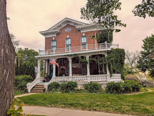 706 4th St, Red Wing, MN 55066 - italianate-style house featuring brick siding, a balcony, covered porch, and a yard