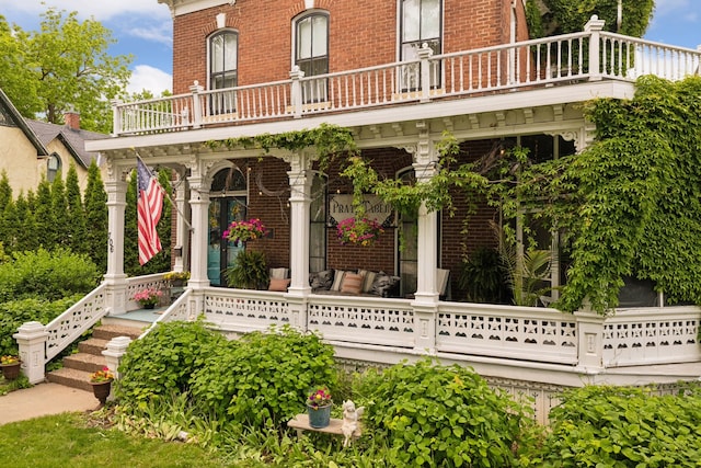 706 4th St, Red Wing, MN 55066 - view of exterior entry with a balcony, brick siding, and a porch