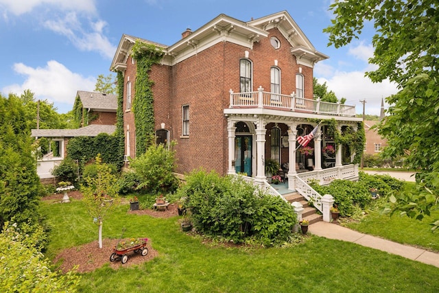 706 4th St, Red Wing, MN 55066 - back of house with brick siding, a yard, a chimney, covered porch, and a balcony