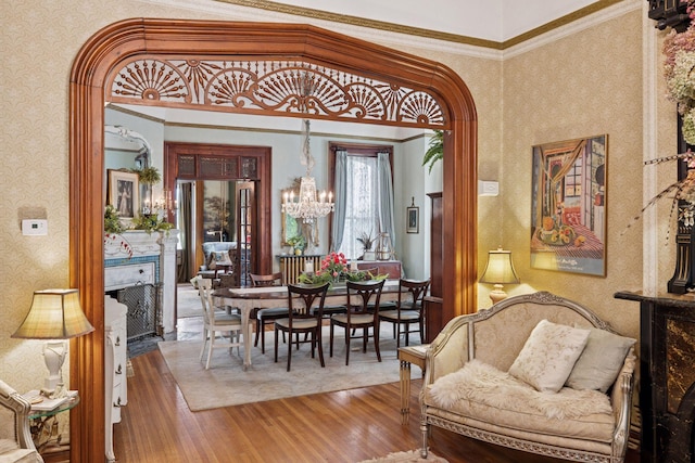 706 4th St, Red Wing, MN 55066 - dining area with wallpapered walls, a chandelier, wood finished floors, and ornamental molding
