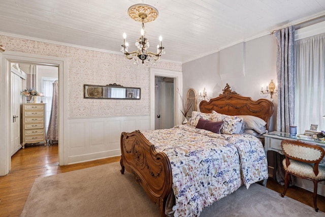706 4th St, Red Wing, MN 55066 - bedroom with a chandelier, light wood-style flooring, wainscoting, ornamental molding, and wallpapered walls