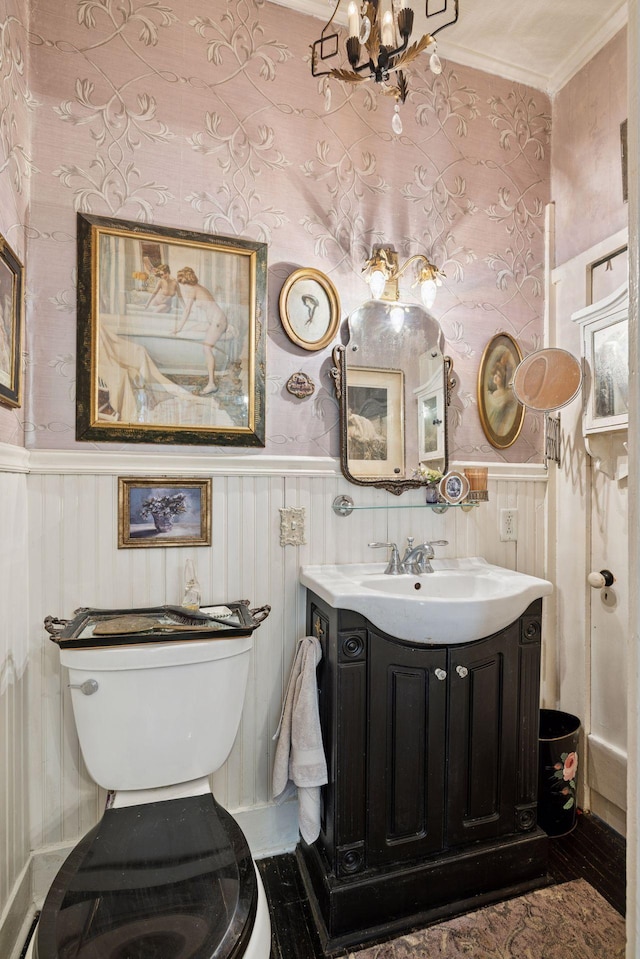 706 4th St, Red Wing, MN 55066 - half bathroom with vanity, a wainscoted wall, a chandelier, and crown molding