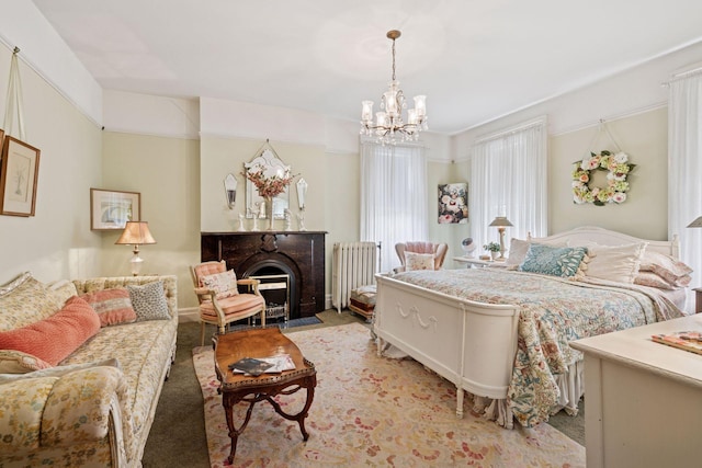 706 4th St, Red Wing, MN 55066 - bedroom with radiator heating unit, a chandelier, light colored carpet, and a fireplace with flush hearth