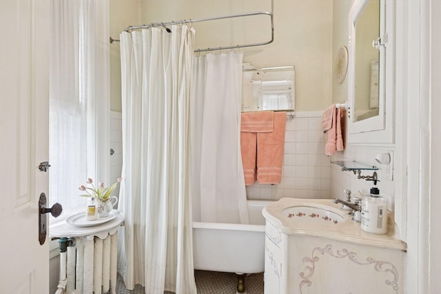 706 4th St, Red Wing, MN 55066 - bathroom featuring a sink, tile walls, wainscoting, and shower / bath combination with curtain