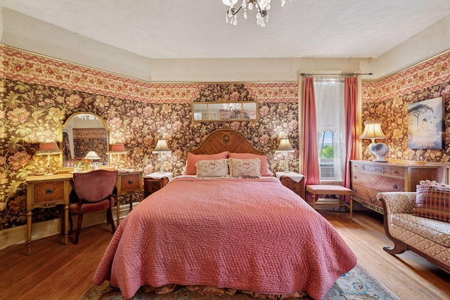706 4th St, Red Wing, MN 55066 - bedroom featuring wallpapered walls, wood finished floors, and a chandelier
