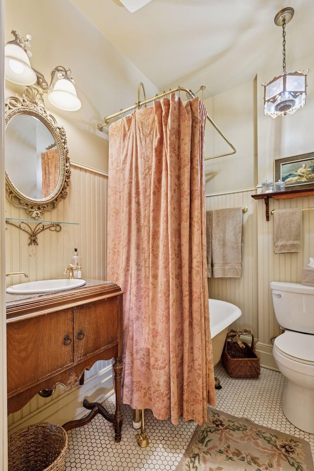 706 4th St, Red Wing, MN 55066 - bathroom featuring toilet, wainscoting, tile patterned flooring, vanity, and a shower with shower curtain