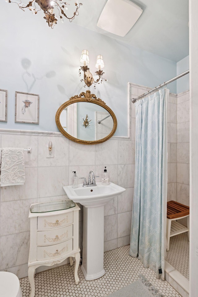706 4th St, Red Wing, MN 55066 - bathroom featuring tile walls, tiled shower, a wainscoted wall, and tile patterned floors